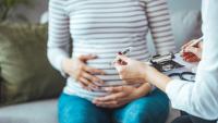 pregnant woman in a striped shirt holding her belly